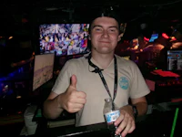 a man giving a thumbs up in a bar